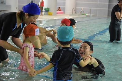 写真：千代田幼稚園のプールで水泳の指導をする田中 雅美さんと園児