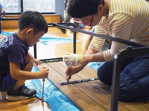 写真：ベンチを組み立てる大人と子ども