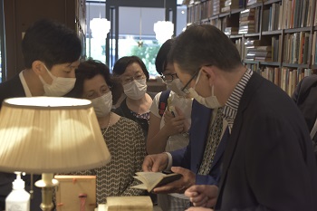 写真：神田神保町の古書市場視察で、皆が古書の説明を熱心に聞く様子