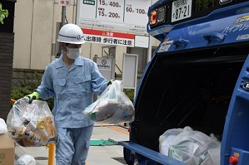 写真：樋口区長が回収したごみを船に積み込んでいる様子