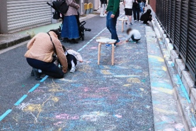 写真:道路にお絵描きをする子どもたち